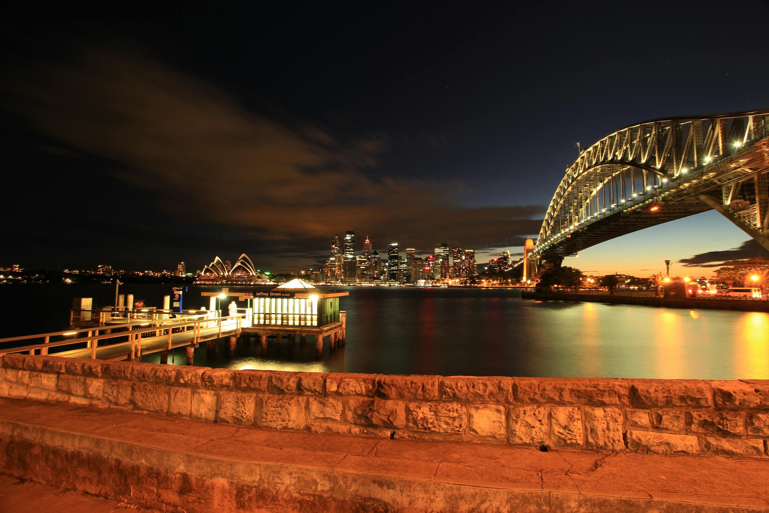 Stunning night view of Sydney Harbour Bridge with the illuminated city skyline and waterfront.