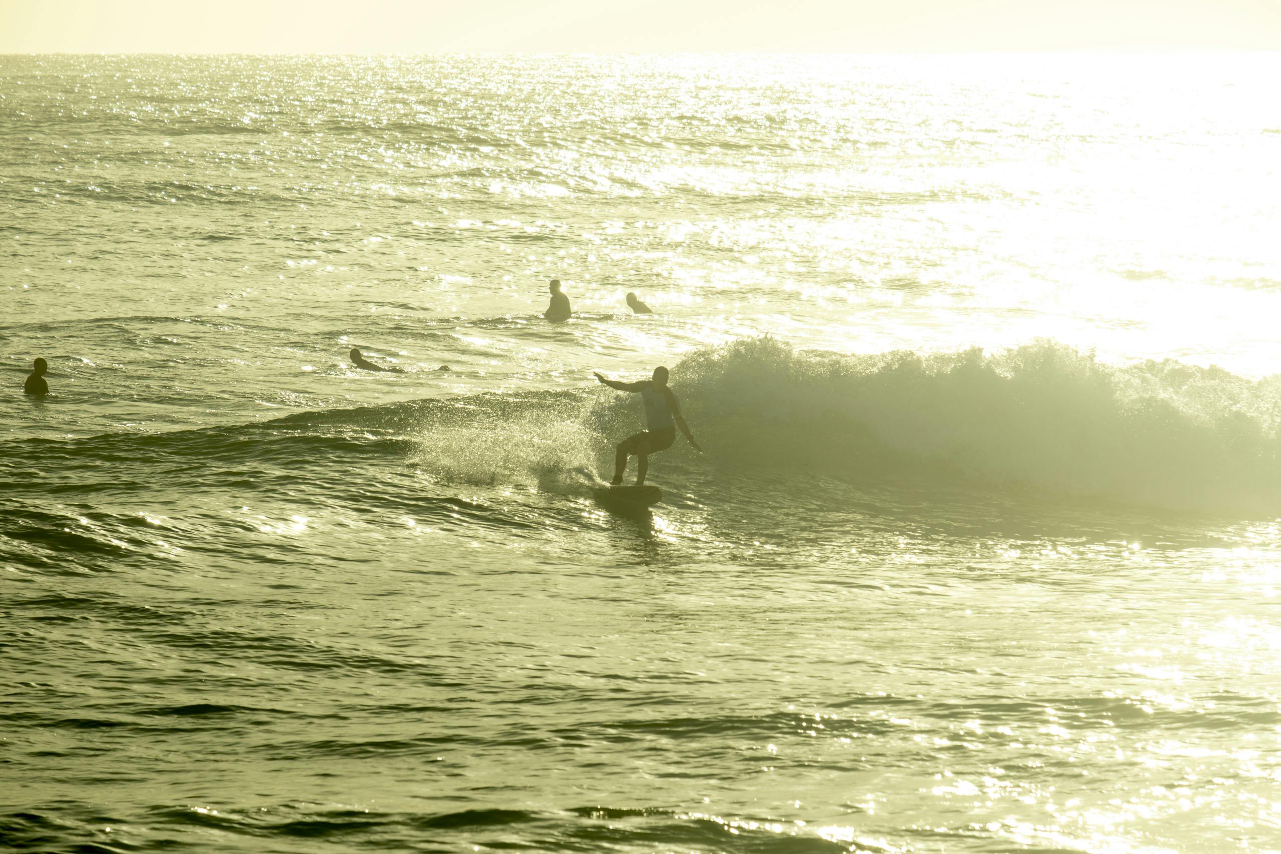 Surfer riding wave while others watching